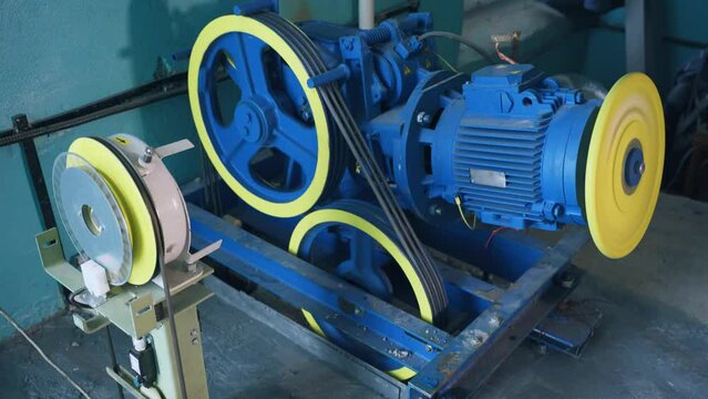 Elevator cabin lifting mechanism. The building has new elevator equipment, an electric drive and a lifting mechanism motor. Elevator motor with cables in a building.