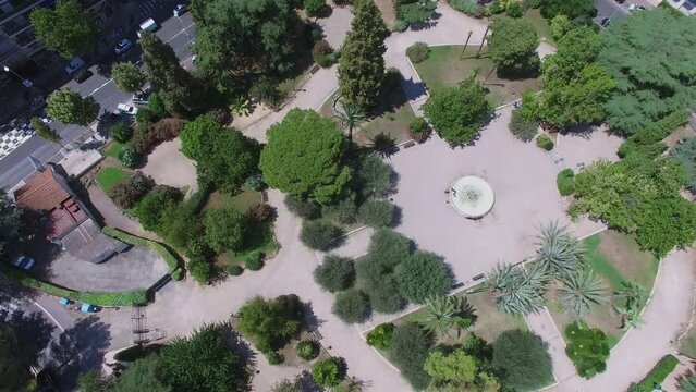 Fountain on square among plants and townscape at summer