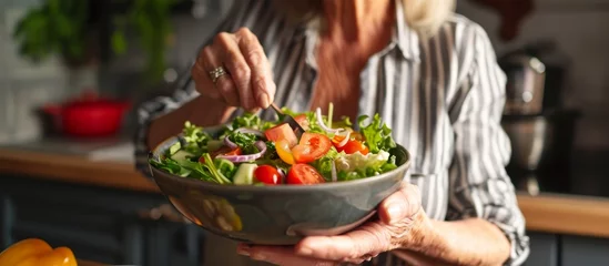 Fotobehang Senior Woman Enjoying a Very Healthy Vegan Salad © AkuAku