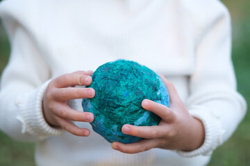 Little girl, kid hand holding the earth in her hands. Earth day. Green concept. Concept for...