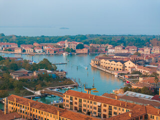 Aerial view of Murano island in Venetian lagoon sea from above, Italy at sunset