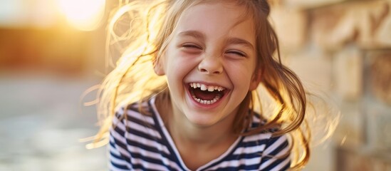 Young Girl in Striped Shirt Bursting with Laughter as She Poses Playfully