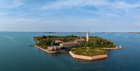 Fototapeta na wymiar Aerial view of the plagued ghost island of Poveglia in the Venetian lagoon, opposite Malamocco along the Canal Orfano near Venice, Italy.