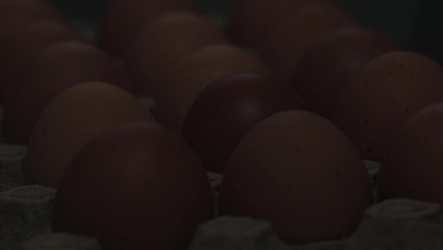 Video macro detail of brown eggs with warm light passing over them. Food concept.