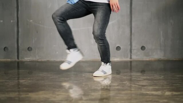 Legs of man which make break-dance on floor. 