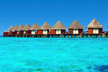 Water villas stand abreast in Maldivian sea 1