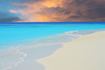 Fototapeta na wymiar Waves on beach in Maldivian sea under dramatic sky