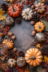 Fototapeta na wymiar Autumn holiday frame with decorative pumpkins, dried foliage, berries, pinecones, and acorns