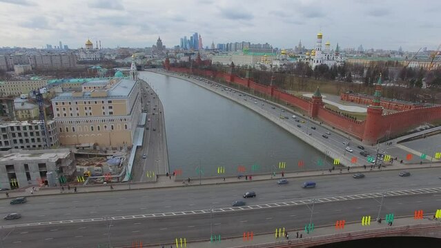 City traffic on bridge and quay near Kremlin complex at spring day