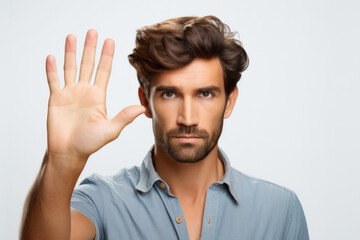 business, gesture and people concept - young man making stop gesture over white background