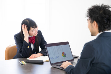 パソコンを使って塾や進路相談の面談などをする学生と先生 合格率厳しそう… あちゃ～～の顔