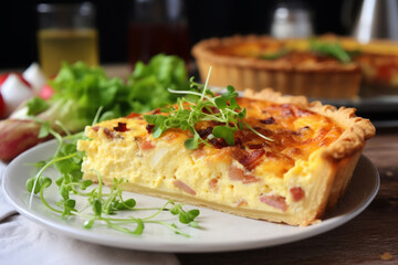 Quiche lorraine slice with fresh green salad on a plate