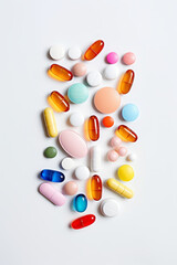 Varity of pills and medicine tablets and capsules on white, medication and overmedication problem concept