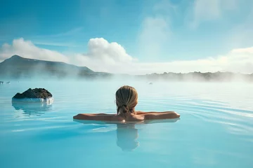 Poster Young woman enjoying spa in hot springs in Iceland. Beautiful girl having fun in thermal bath on a backdrop of scenic Icelandic nature. © MNStudio