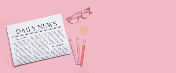 Newspaper with eyeglasses and stationery on pink background with space for text