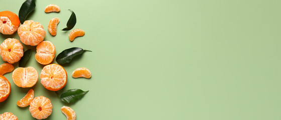Sweet peeled tangerines on green background with space for text, top view