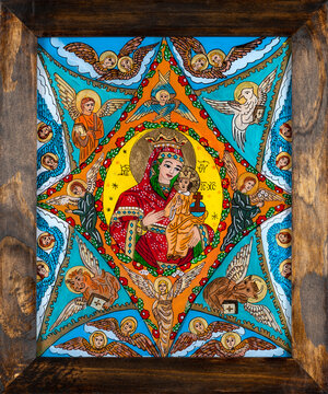 Icon painted on reverse glass in the naive orthodox style of Eastern Europe depicting Virgin Mary and baby Jesus. Framed icon.