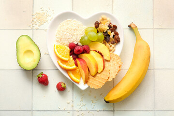 Plate with fresh healthy products on light tile background. Diet concept
