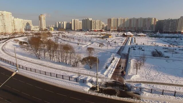 Car traffic on round square with park among residential houses