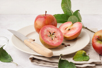 Plate with sweet pink apples and seeds on white background