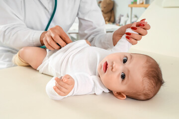 Female pediatrician listening to little baby with stethoscope in clinic, closeup