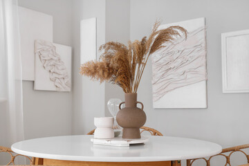 Vase with pampas grass on dining table in stylish room