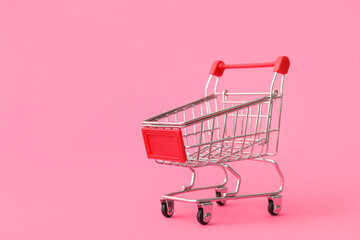 Small shopping cart on pink background. Valentine's Day celebration