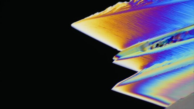 Neon Dreams of Ascorbic Acid: growth of vitamin C crystals under the microscope in polarized light expanding across the frame. Perfect for educational, artistic, and scientific projects. Time lapse