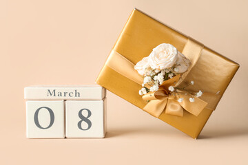 Cube calendar with date 8 MARCH, gift box, beautiful roses and gypsophila flowers on yellow background. International Women's Day