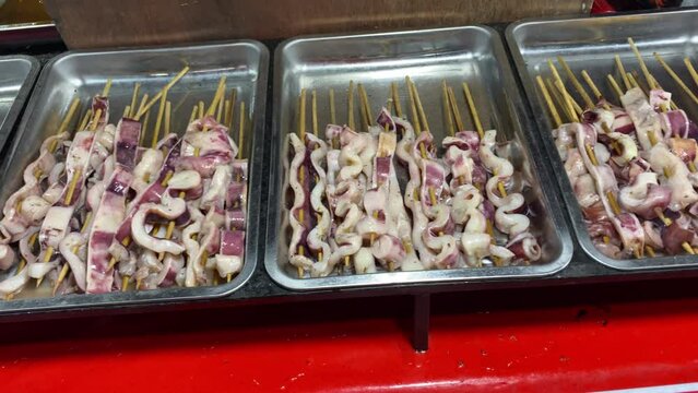 4k video footage of Squid satay in stainless steel tray. Seafood dish that is often sold at street food stalls.