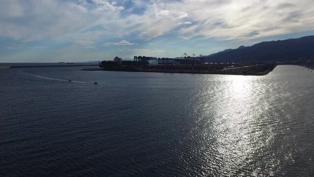 Two boats sail near container terminal Voltri Europa at summer