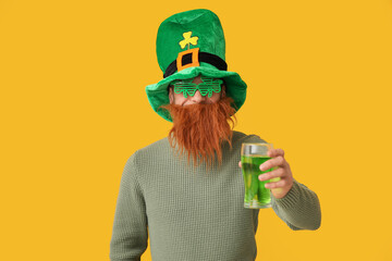 Funny bearded man in leprechaun hat and decorative glasses in shape of clover with glass of beer on...