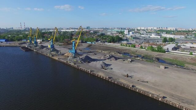 Several cranes in South River Port with piles of sand 