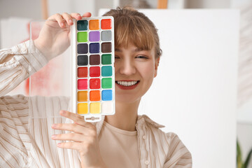 Female artist with paints in workshop, closeup