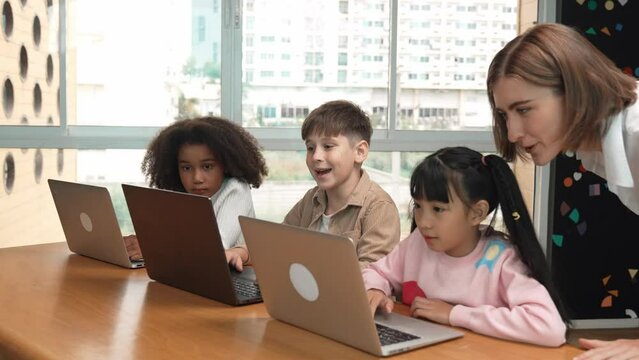 Smart teacher teaching and looking student using laptop at classroom. Professional instructor explained about programing engineering code or prompt while studying and learning program. Erudition.