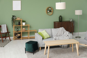 Interior of stylish living room with sofa, table and pouf
