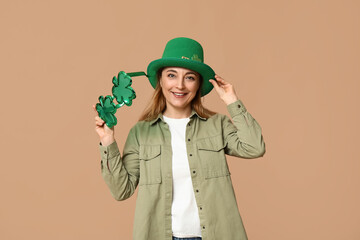 Mature woman in hat with eyeglasses on beige background. St. Patrick's Day celebration