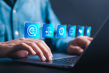 Copyright or patent concept. Businessman use laptop with virtual screen of copyright symbol for author rights and patented intellectual property. copyleft trademark license.