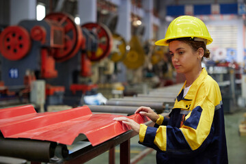 worker or technician checking quality metal sheet from machine in the factory