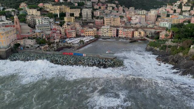 Big foamy sea waves crashing on pier wave braker in Genoa city harbor.