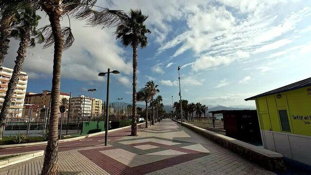 Coastal boulevard walkway lined with palm trees and hotels in Malaga - Spain