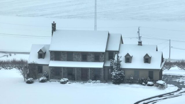 Aerial view of a snow-covered house on a hill. Large American property.