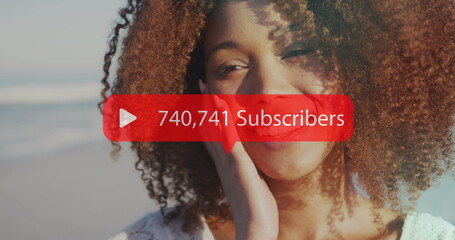 Image of speech bubble with subscribers numbers over smiling woman on beach
