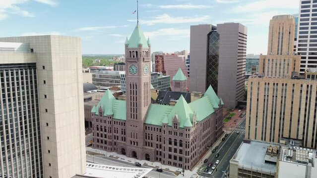Drone push in downtown Minneapolis towards city hall clock tower on a spring afternoon 4k