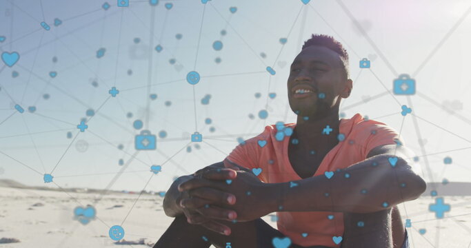 Image of network of connections with digital icons over happy man on beach