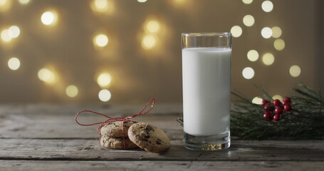 A glass of milk and cookies on a wooden table, with copy space