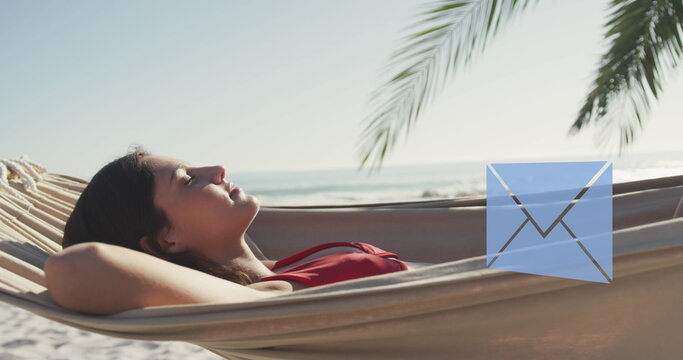 Image of email envelope digital icons over woman lying in hammock on beach
