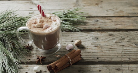 A festive hot chocolate sits on a wooden table, with copy space