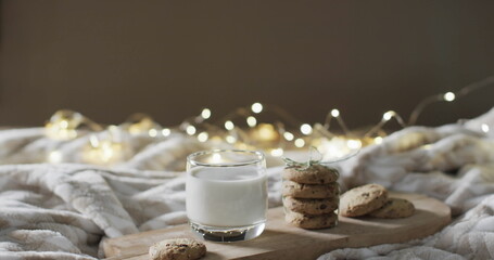 Fototapeta na wymiar A glass of milk and cookies on a cozy bed setup, with copy space
