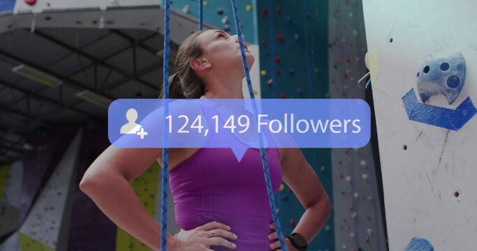 Social Media icon floating in front of caucasian woman on climbing wall - Powered by Adobe